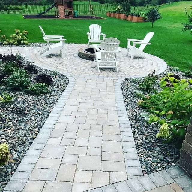 Completed retaining wall and patio hardscape installation in a residential landscape