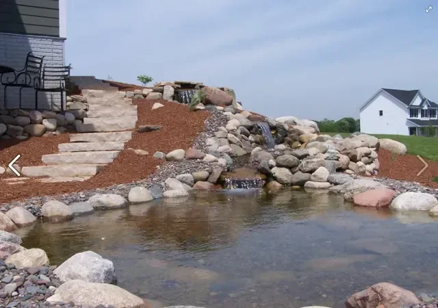 Pondless water feature with stone and flowing water in a residential landscape