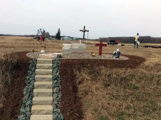 Concrete steps with stone edging, gravel beds, and crosses in cemetery landscape installation