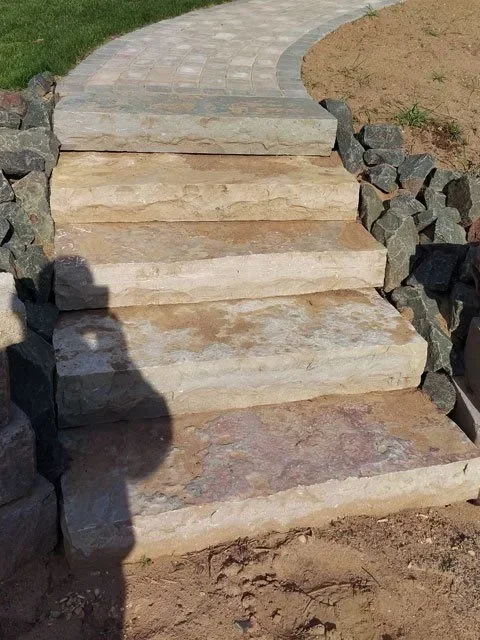 Natural stone steps with retaining walls and paver patio integration