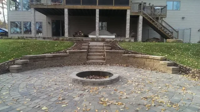 Circular paver patio with fire pit, retaining walls, and landscape beds